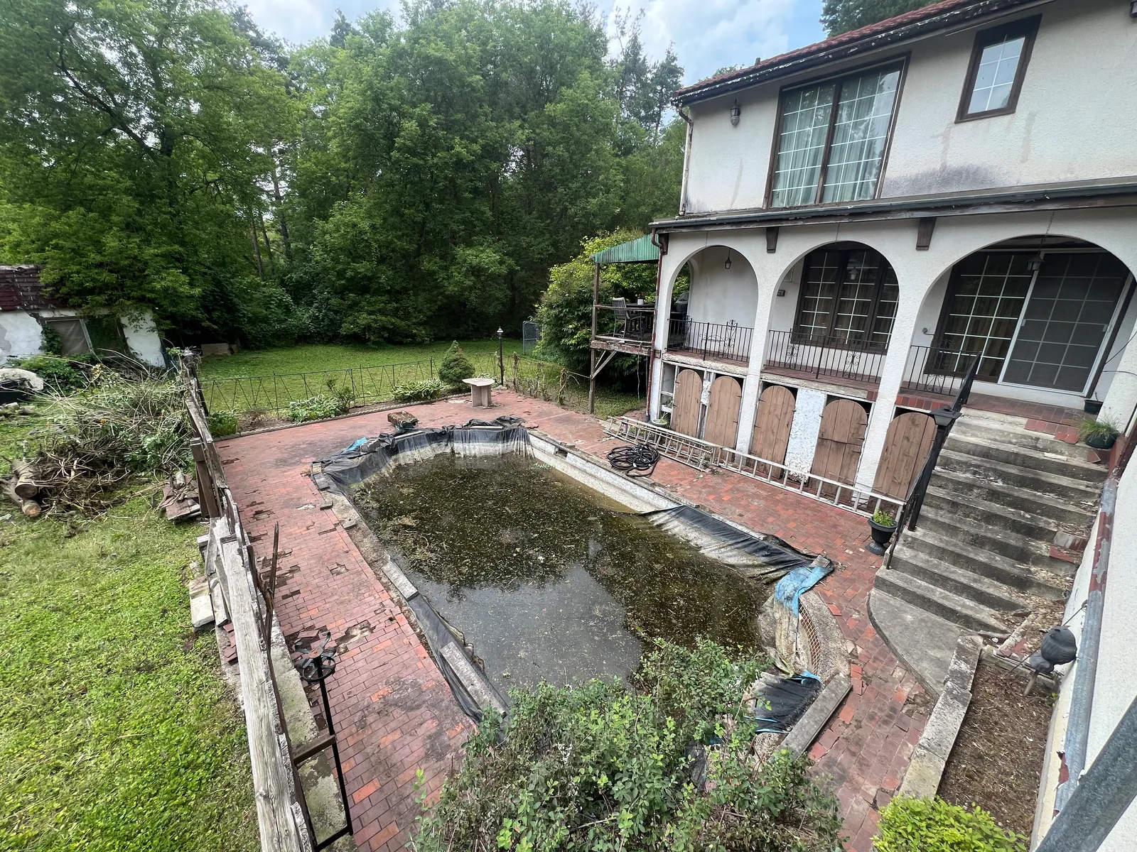 Pool and patio area after surrounding overgrowth and debris were cleared